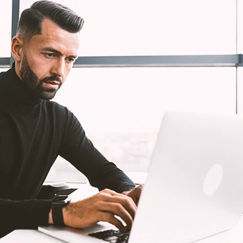 A man seriously looking at his laptop