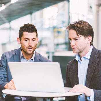 Two coworkers looking at a laptop