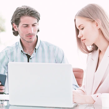 Two coworkers looking at a laptop