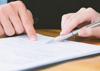 Two persons pointing at a paper