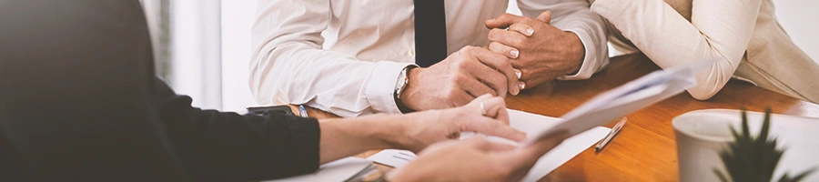 Three people discussing paperwork