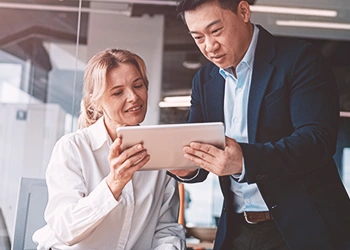 Two coworkers looking at a tablet