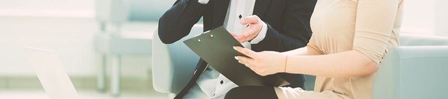 Two coworkers looking at a clipboard