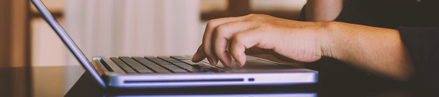 A woman looking up for an LLC in Hawaii on laptop