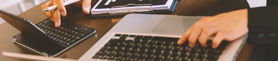 Two person working on two laptops on a table