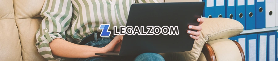 A person holding a laptop while on a couch, with the Legalzoom logo