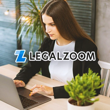 A person typing on a laptop in an office with the Legalzoom logo