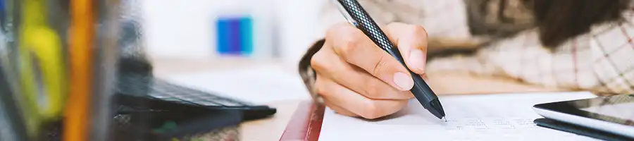 An office worker writing down on a notebook