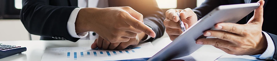 Two people pointing their finger to a tablet