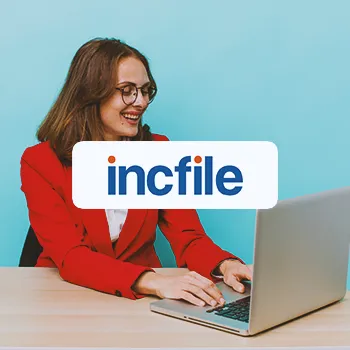 A businesswoman using a laptop with the incfile logo in the foreground