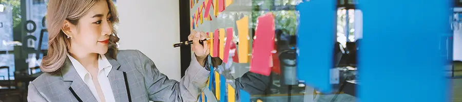 An office worker writing down on sticky notes