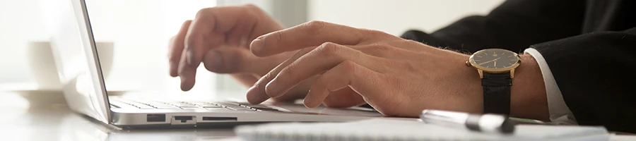 An image of a man searching for LLC formation process in Arkansas using a laptop