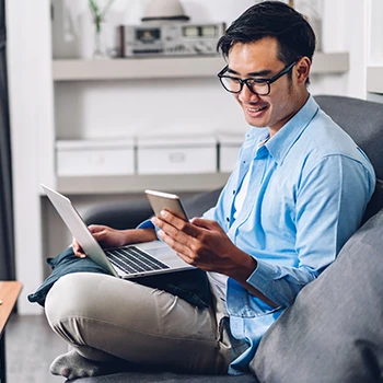 A man sitting on a couch while looking up an LLC in Vermont