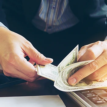 A business man counting dollars for the registered agent service cost in Mississippi