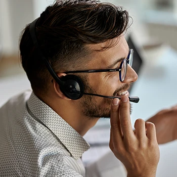 An image of a man wearing a headset and talking to a customer