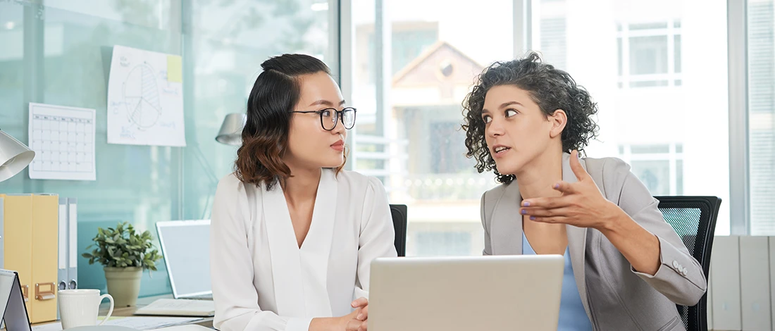 Two women talking about Northwest registered agent service in an office