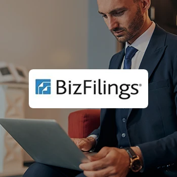 A young businessman sitting while using a laptop and a logo of BizFilings