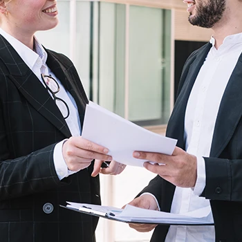 Two people talking while handing over the certificate of compliance