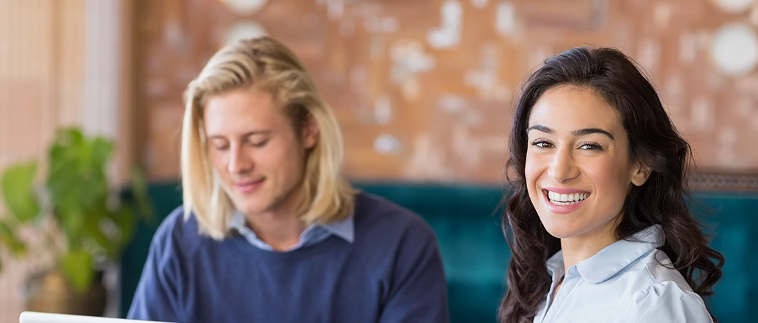 A smiling woman talking to her business partner about the cheapest LLC filing services