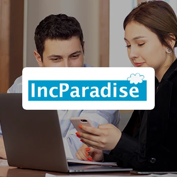 IncParadise logo and two individuals talking about something in front of a laptop