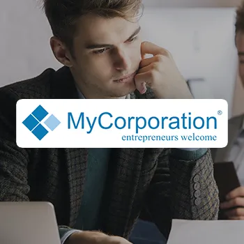 A young handsome man working in an office and a logo of MyCorporation LLC