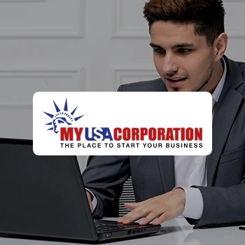 A young entrepreneur working on a laptop and a logo of MyUSAcorporation