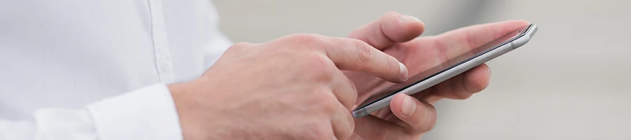 A close up shot of a man reading something in his phone