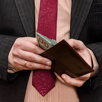 A close up shot of a business man checking money from his wallet