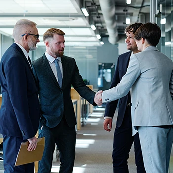 A group of individuals talking while shaking hands