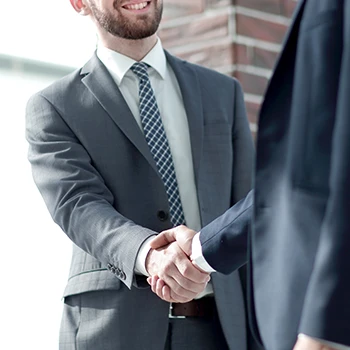 Two gentlemen shaking hands happily