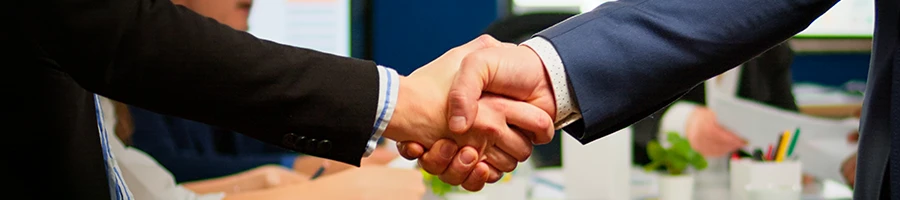 A close up shot of two people shaking hands in an office