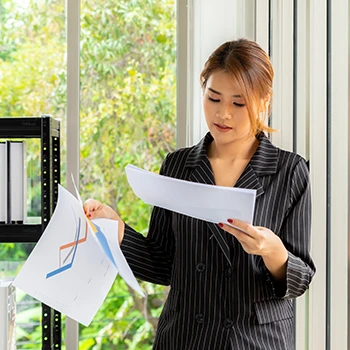 A business woman in her office reading annual reports