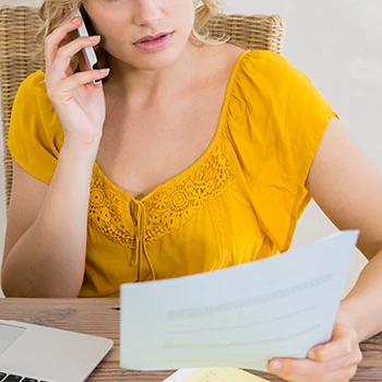 A woman on a phone call holding the certificate of existence