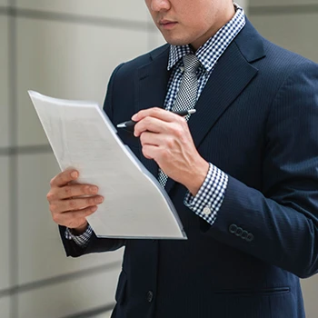 A business man holding and reading a periodic report