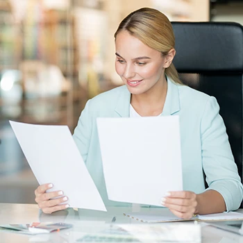 A smiling business woman who reads some documents in her office