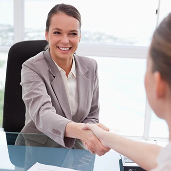 Two women shaking hands closing a deal after hiring a registered agent service in Georgia