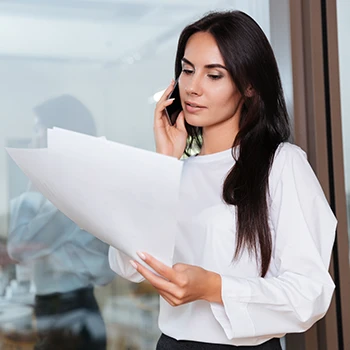 A business woman reading the certificate of existence while on a phone call