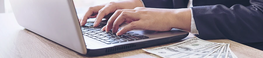 A woman working on her taxes with money on the side