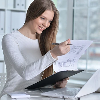 A smiling woman reading annual reports