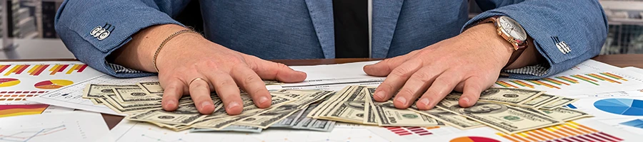 A business man arranging money and paper works on his desk