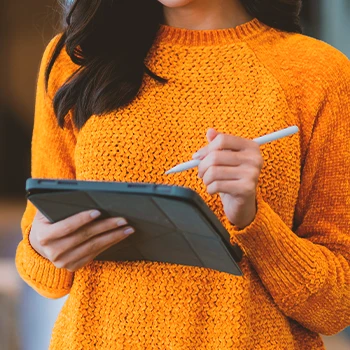 A woman holding a tablet while working