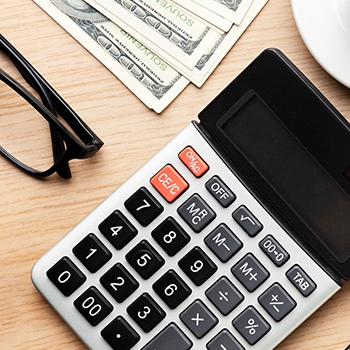 Top view of calculator, glasses and money