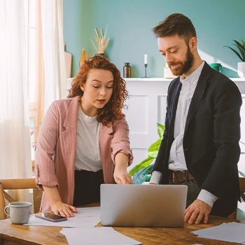 Two office workers talking to each other about filing paperwork online