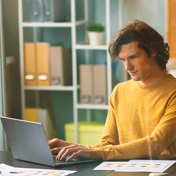 A person using a laptop to file paperwork online