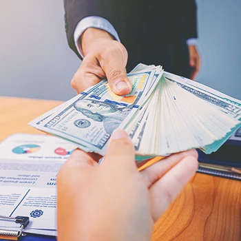 An office worker passing money to another worker