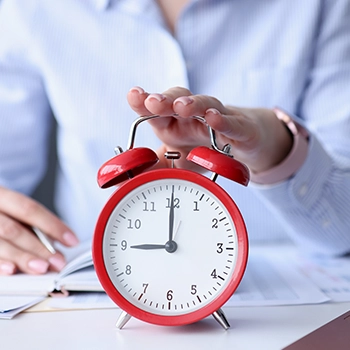 Holding a red clock on a table