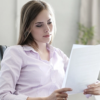 A woman checking multiple documents to find what are the risks of becoming registered agent for her own LLC