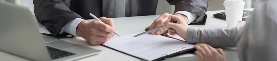 Two people talking about business and writing on a clipboard about how to change an LLC name in Colorado