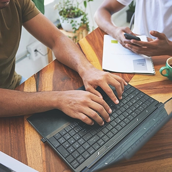 Using a laptop to search the internet for how to start a coffee shop business