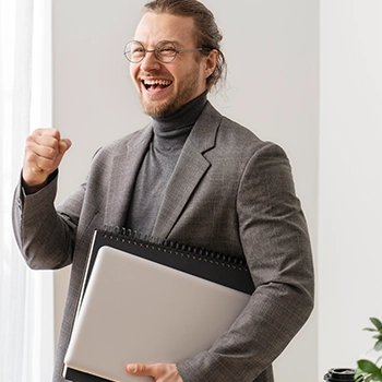 Happy man holding a laptop and documents